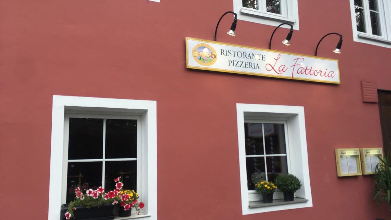 Fassade der Pizzeria La Fattoria mit Blumen